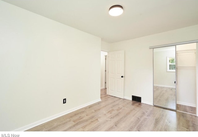 unfurnished bedroom featuring a closet and light hardwood / wood-style flooring