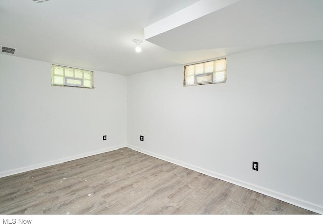 basement with plenty of natural light and light hardwood / wood-style floors