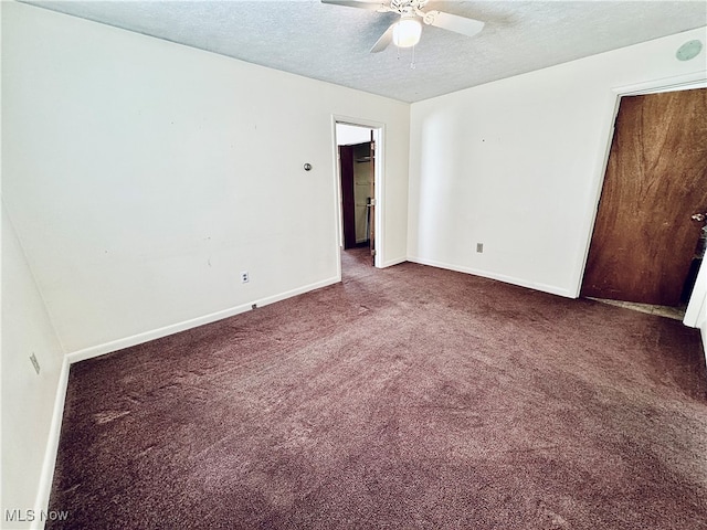 unfurnished bedroom featuring a textured ceiling, dark carpet, and ceiling fan