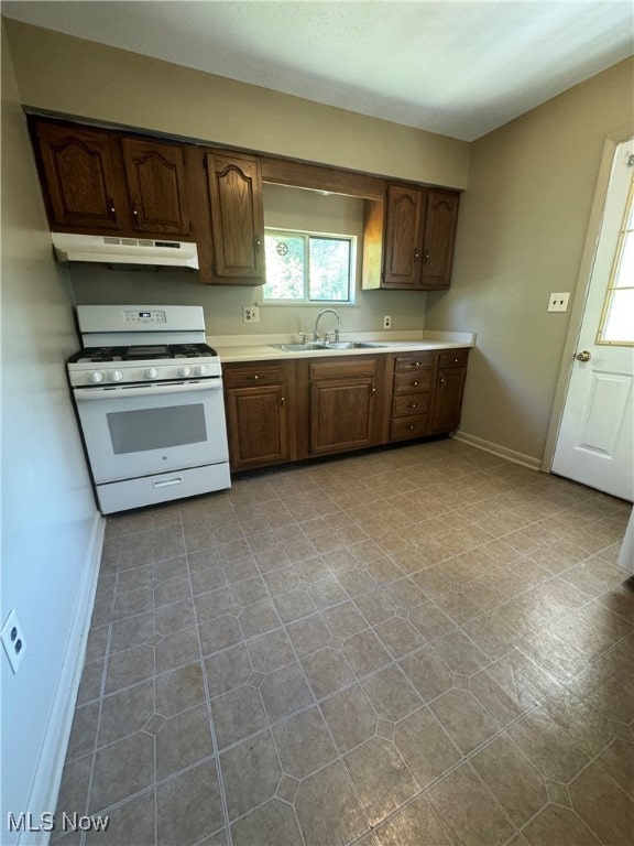 kitchen with sink, white range with gas stovetop, and dark brown cabinets