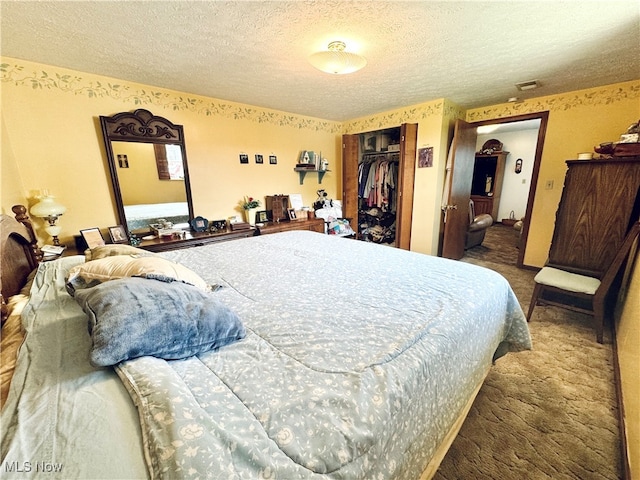 carpeted bedroom with a textured ceiling and a closet