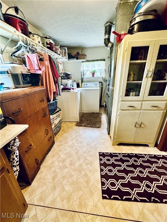 laundry area featuring washer and clothes dryer and a textured ceiling