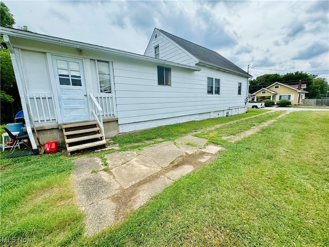 rear view of house featuring a lawn