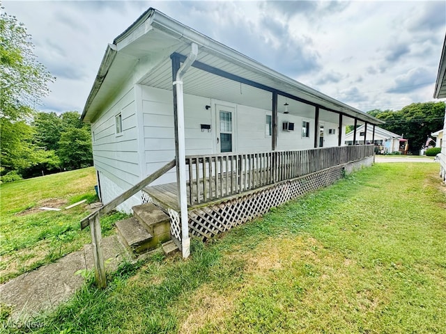 view of side of property with covered porch and a lawn