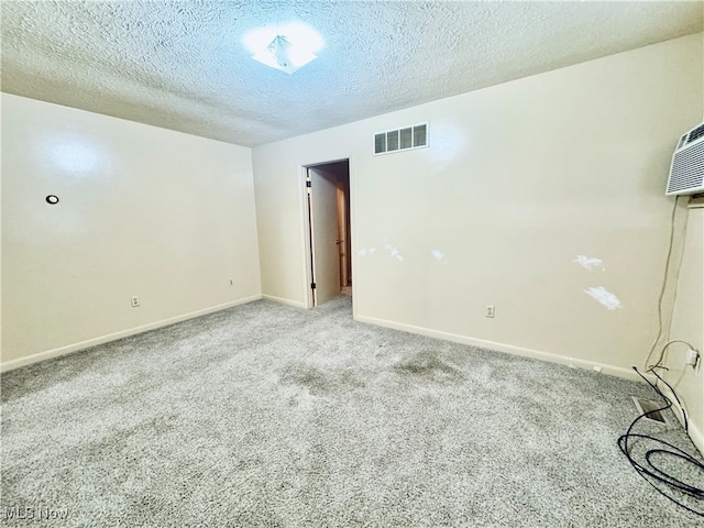 empty room featuring a textured ceiling and light carpet