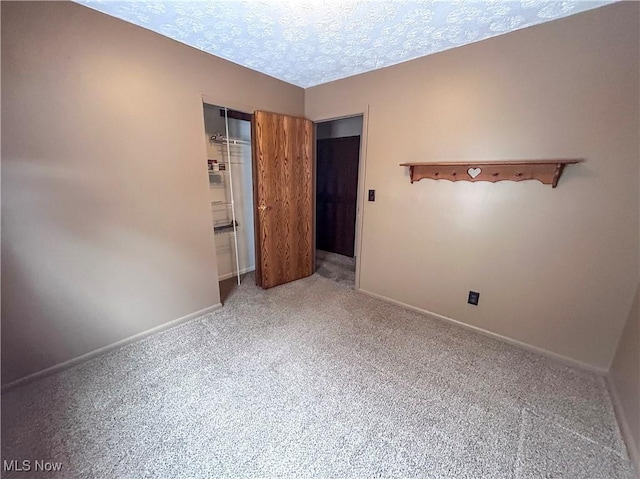 unfurnished bedroom with carpet flooring, a closet, and a textured ceiling