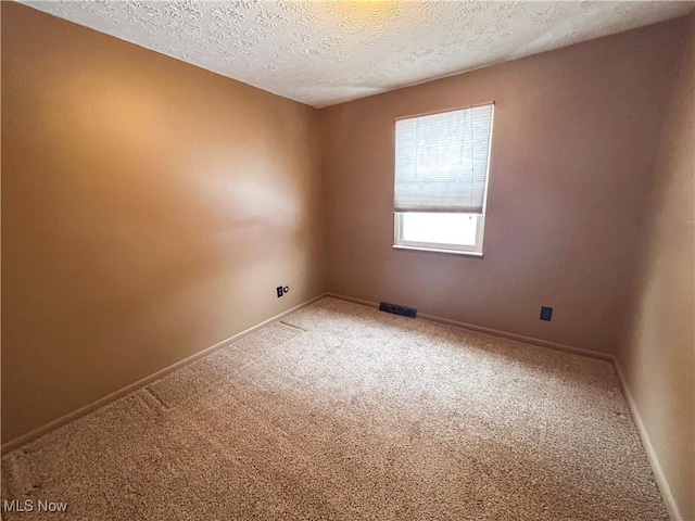 carpeted spare room with a textured ceiling