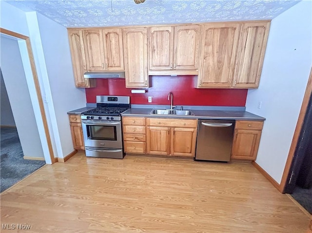 kitchen with sink, stainless steel appliances, a textured ceiling, and light hardwood / wood-style flooring