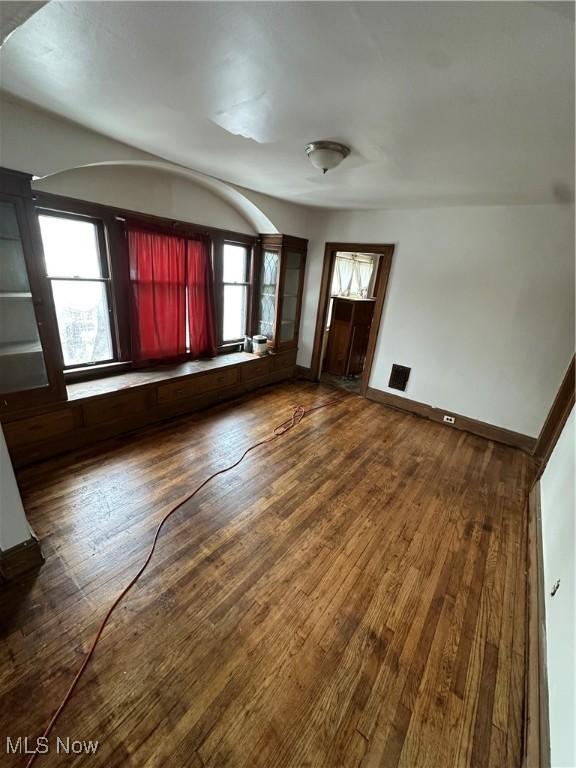 interior space featuring baseboards and dark wood finished floors