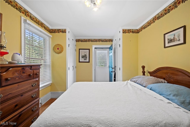 bedroom with wood-type flooring and ornamental molding