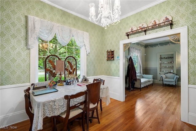 dining area featuring a notable chandelier, hardwood / wood-style flooring, and ornamental molding