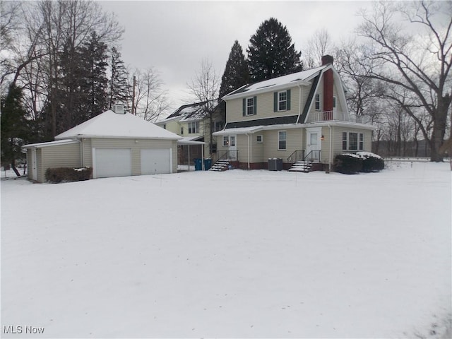 view of front of property with a garage, central AC, and an outbuilding