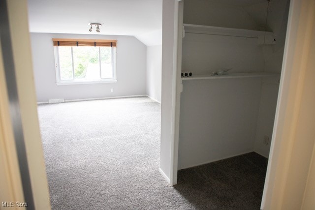 bonus room with lofted ceiling and carpet flooring