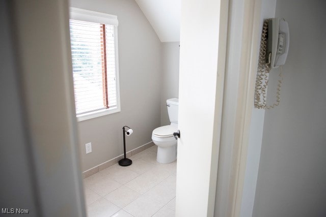 bathroom featuring tile patterned flooring, toilet, and vaulted ceiling