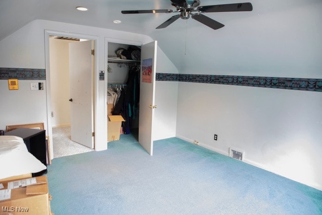 carpeted bedroom featuring ceiling fan, a closet, and lofted ceiling