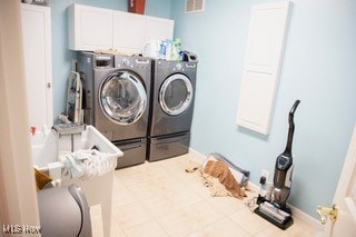 washroom with washer and dryer and cabinets