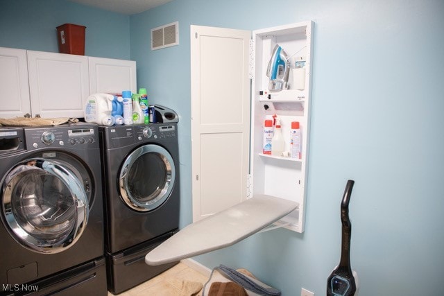 laundry room featuring cabinets, washer and dryer, and tile patterned flooring