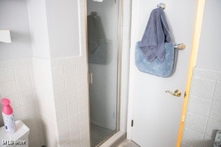 bathroom with toilet and a shower with door