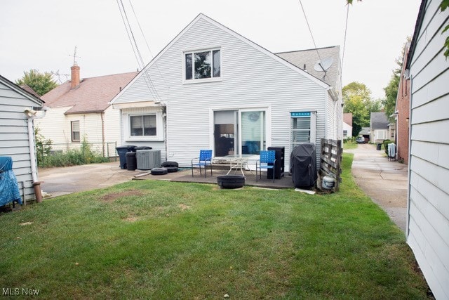 rear view of house featuring a patio area, a lawn, and central AC