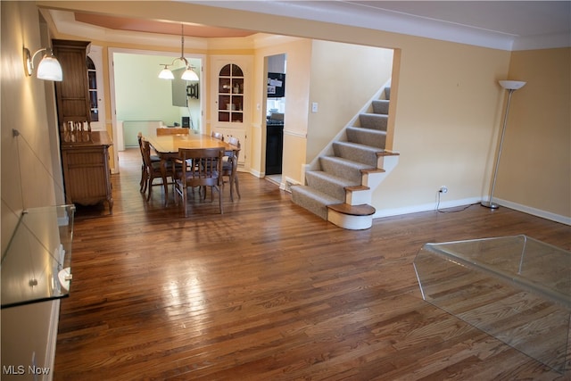 dining area featuring dark hardwood / wood-style flooring and crown molding