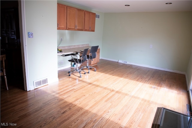 office area featuring built in desk and light hardwood / wood-style flooring