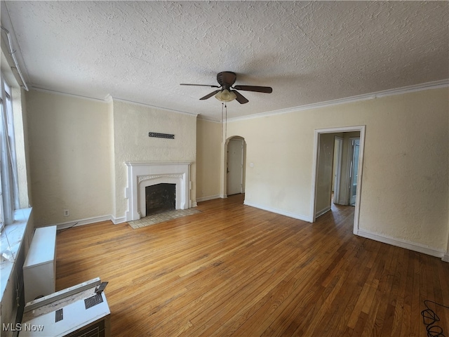 unfurnished living room with crown molding, ceiling fan, hardwood / wood-style flooring, and a textured ceiling