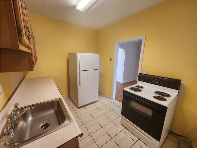 kitchen with light tile patterned floors, sink, and white appliances