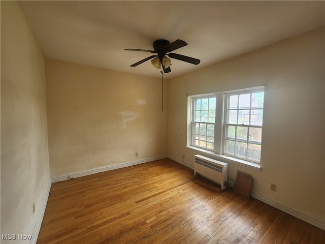 unfurnished room with ceiling fan, light hardwood / wood-style flooring, and a wall unit AC