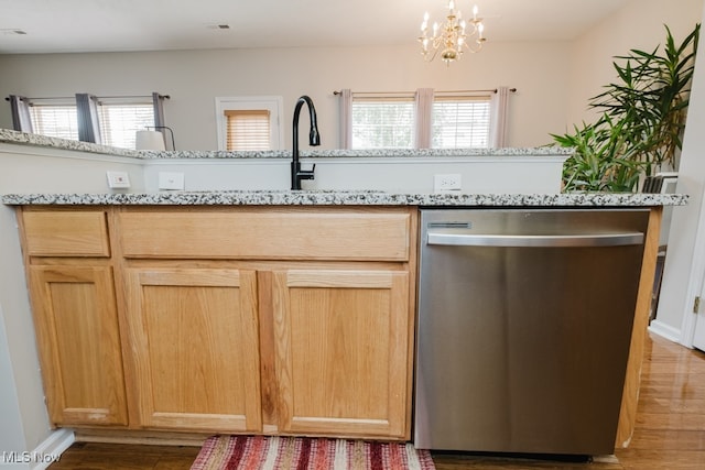 kitchen with a healthy amount of sunlight, stainless steel dishwasher, and wood-type flooring