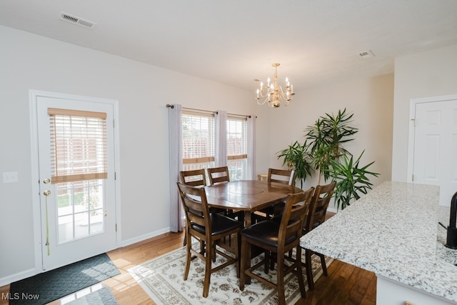 dining space featuring a chandelier, hardwood / wood-style floors, and a healthy amount of sunlight