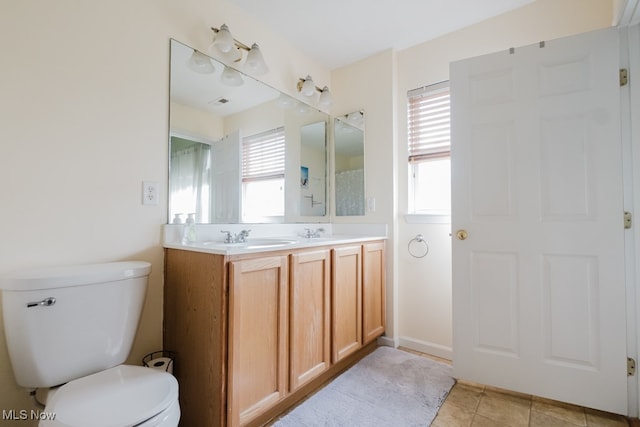 bathroom featuring vanity, tile patterned floors, a healthy amount of sunlight, and toilet