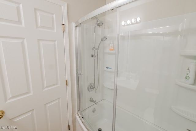 bathroom with bath / shower combo with glass door