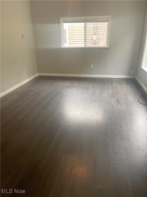 spare room with dark wood-type flooring