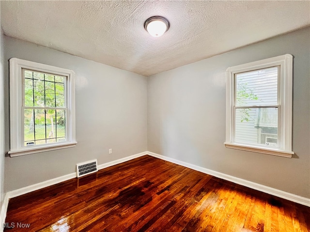 unfurnished room featuring a textured ceiling and wood-type flooring