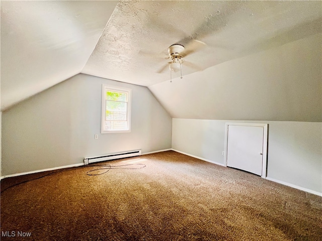 additional living space featuring ceiling fan, a textured ceiling, a baseboard heating unit, carpet floors, and vaulted ceiling