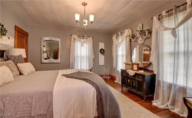 bedroom with a notable chandelier and dark hardwood / wood-style flooring