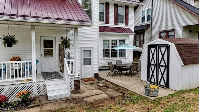 back of property featuring a patio and a storage shed