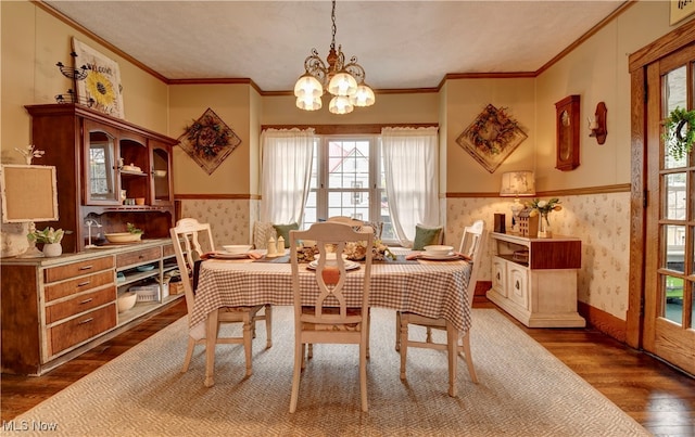 dining area with an inviting chandelier, dark hardwood / wood-style floors, and crown molding