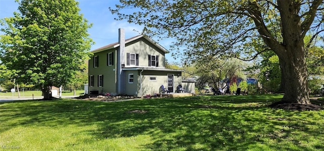 back of house featuring central AC and a yard