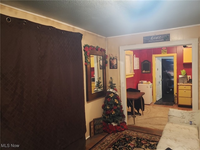 corridor with washer / clothes dryer, light colored carpet, and ornamental molding