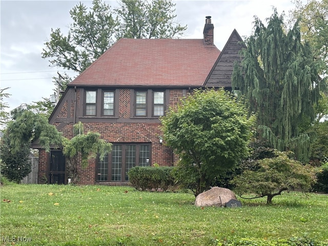 english style home with a front yard