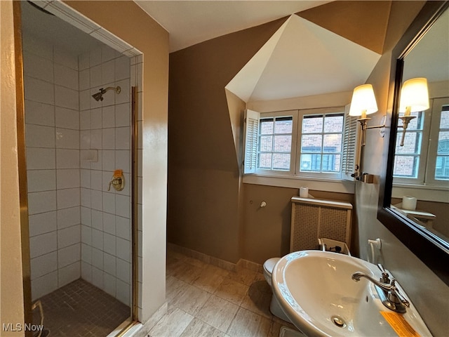 bathroom with toilet, sink, and a shower with shower door