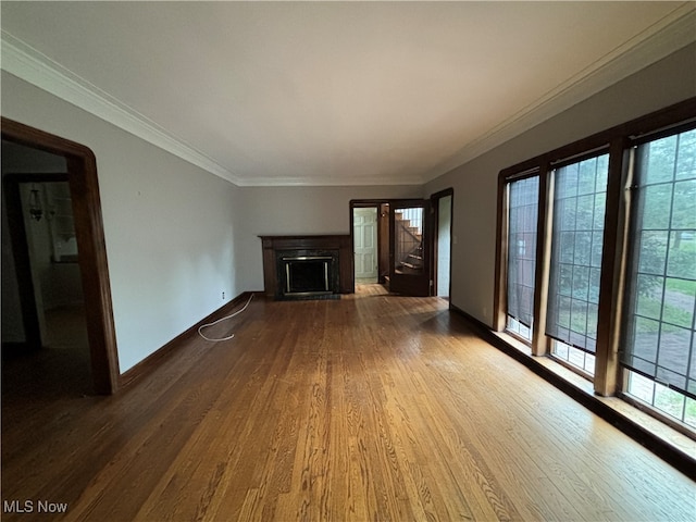 unfurnished living room featuring wood-type flooring and crown molding