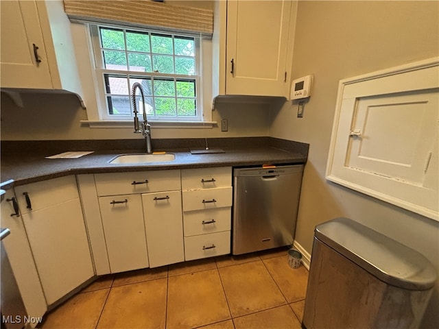 kitchen featuring light tile patterned floors, white cabinets, dishwasher, and sink