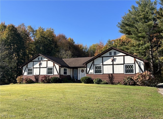 tudor-style house featuring a front lawn