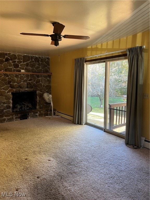 unfurnished living room featuring baseboard heating, carpet, a stone fireplace, and ceiling fan