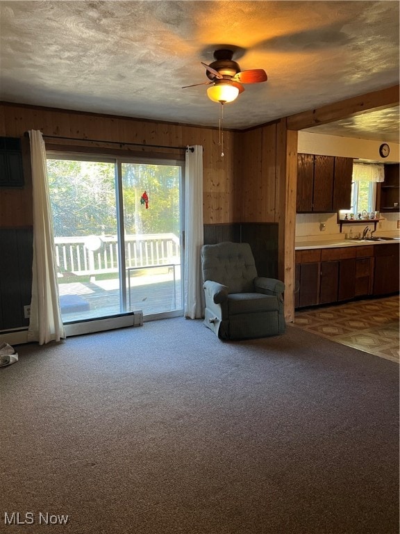 unfurnished room with a wealth of natural light, a textured ceiling, and wood walls