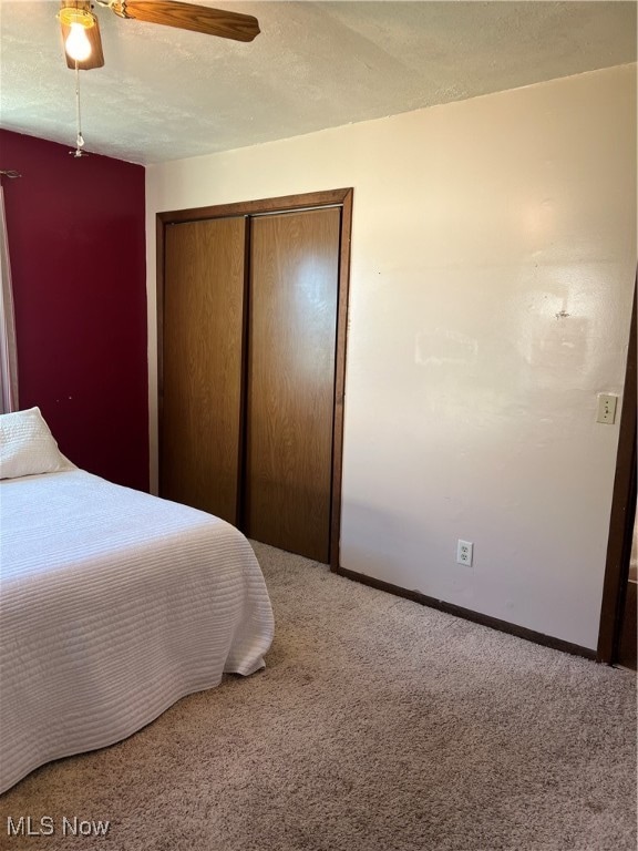 unfurnished bedroom featuring a closet, ceiling fan, and carpet floors