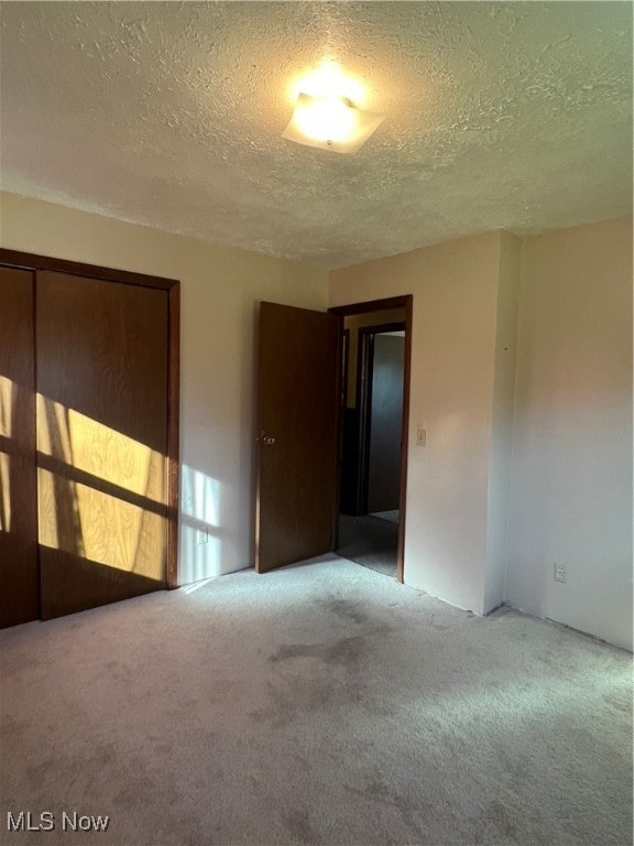 empty room featuring a textured ceiling and carpet flooring