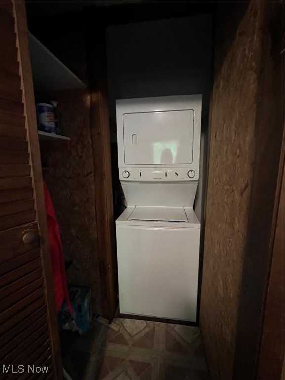 clothes washing area with stacked washer and clothes dryer